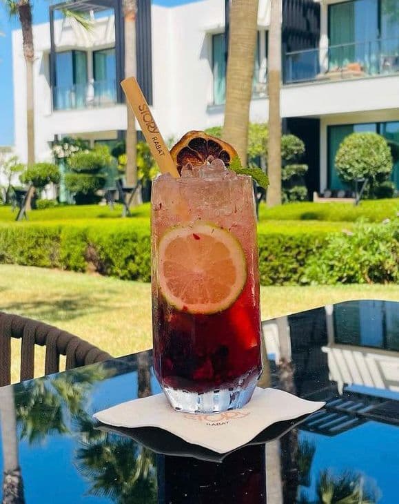 Cocktail rouge aux agrumes dans un jardin d'hôtel